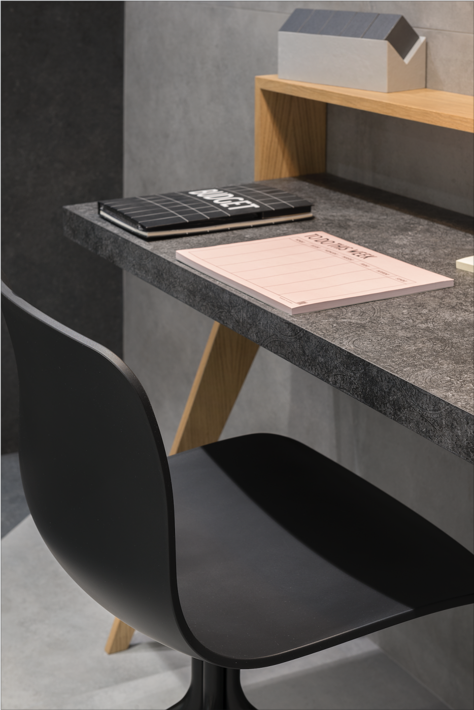 Moderner Schreibtischbereich mit grauen Fliesen an Wand und Tischplatte.